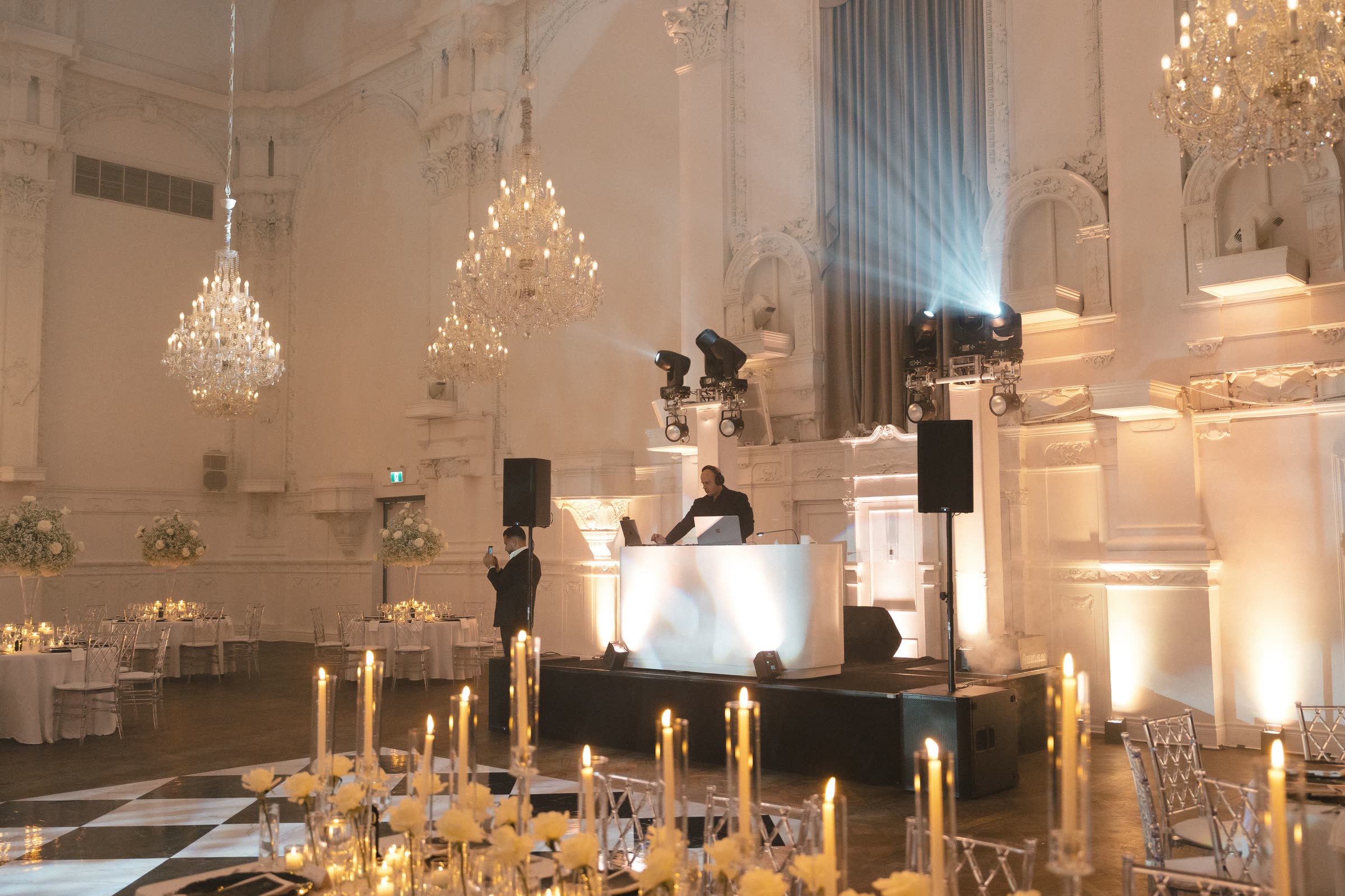 Console blanche et éclairage d'ambiance intégrés avec soin dans une salle de bal à lustres